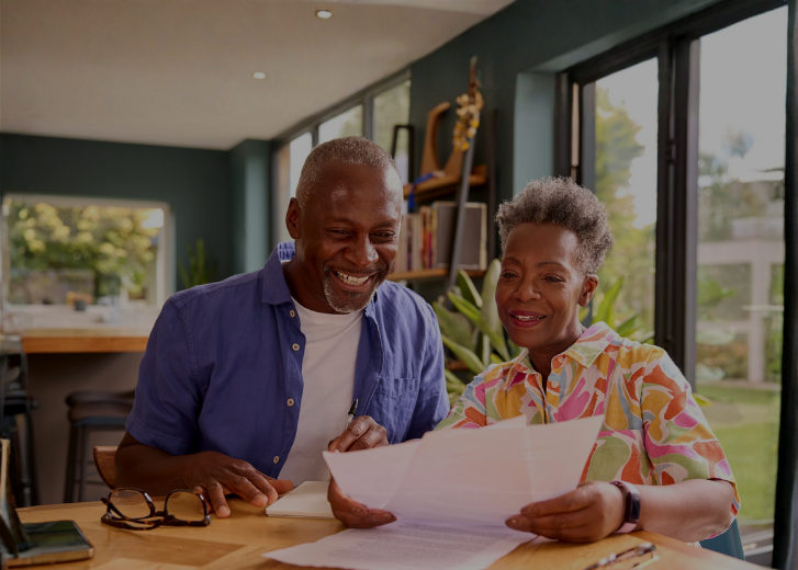 older couple smiling reviewing paperwork